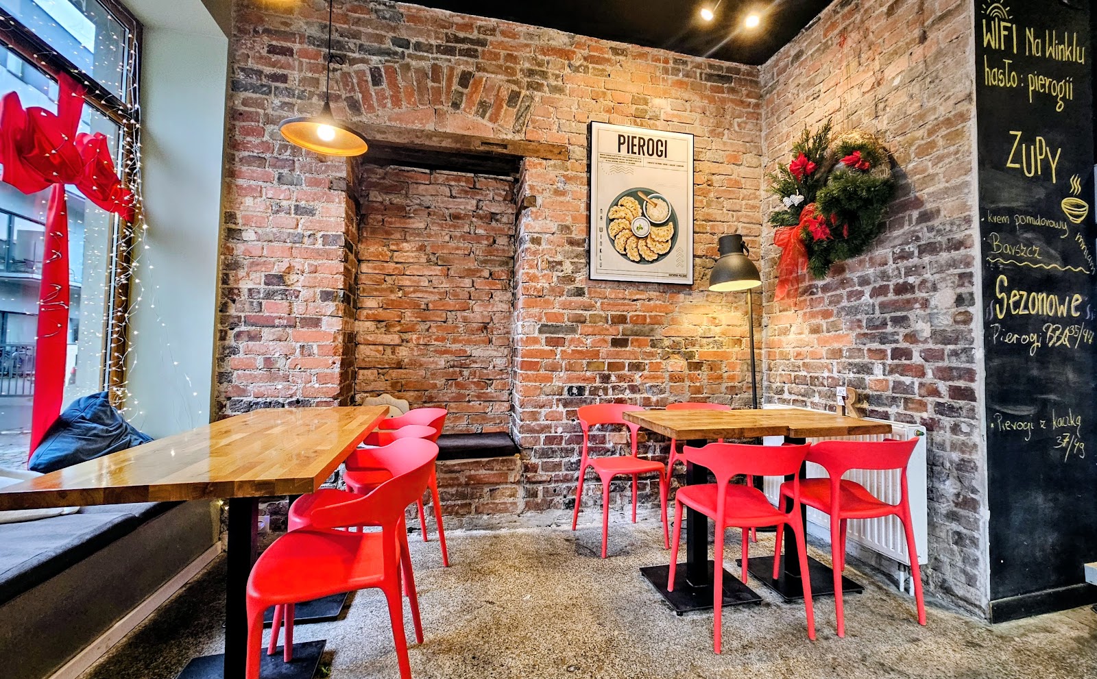 Ceglane wnętrze restauracji Na Winklu z czerwonymi krzesłami